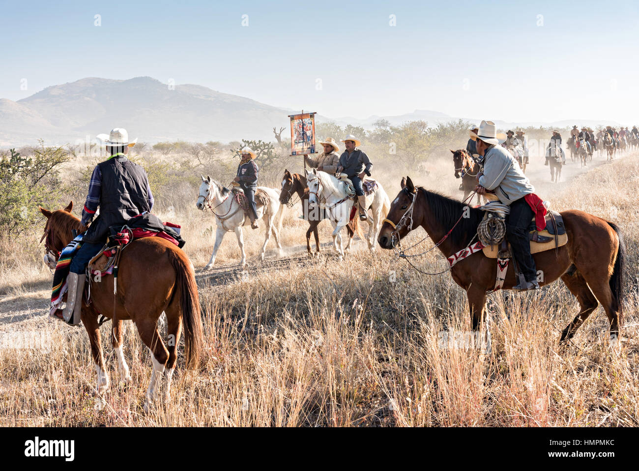 Volunteers watch as hundreds of Mexican cowboys ride past during the annual Cabalgata de Cristo Rey pilgrimage January 5, 2017 in La Trinidad, Guanajuato, Mexico. Thousands of Mexican cowboys and horse take part in the three-day ride to the mountaintop shrine of Cristo Rey stopping along the way at shrines and churches. Stock Photo