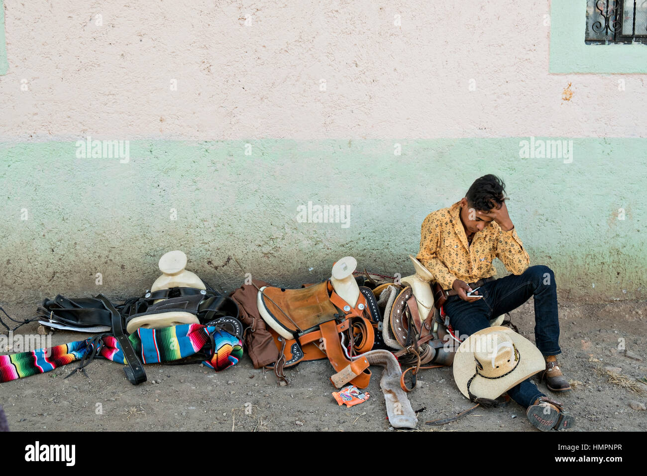 A Mexican cowboy takes a break after arriving to camp at a village stop along the road during the annual Cabalgata de Cristo Rey pilgrimage January 4, 2017 in La Sauceda, Guanajuato, Mexico. Thousands of Mexican cowboys and horse take part in the three-day ride to the mountaintop shrine of Cristo Rey stopping along the way at shrines and churches. Stock Photo