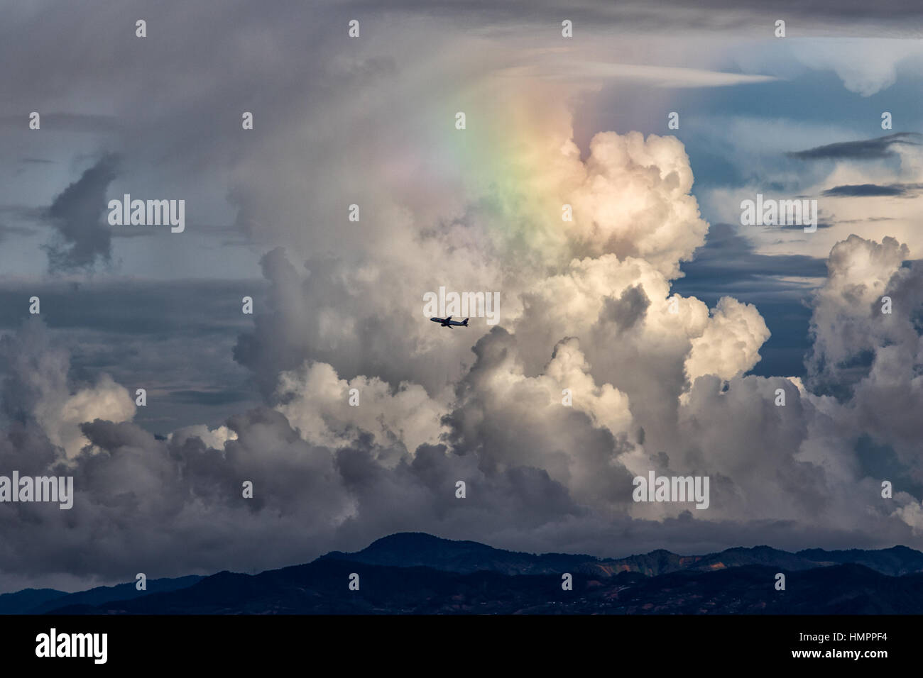 Storm clouds with rainbow and airplane flight Stock Photo - Alamy