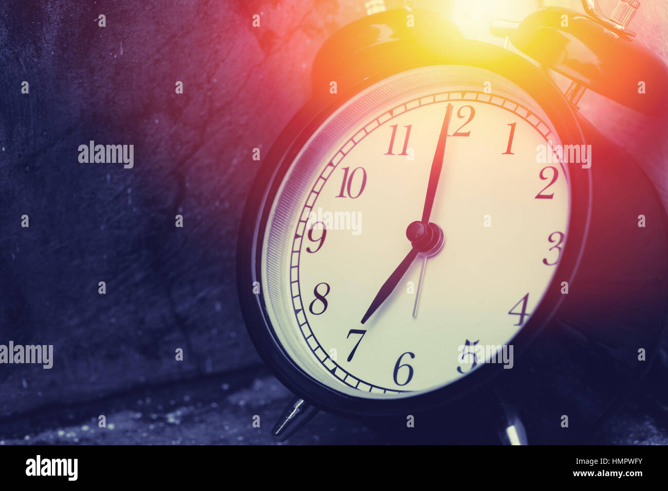 7 o'clock vintage clock at dark color tone with sun light memory time concept. Stock Photo