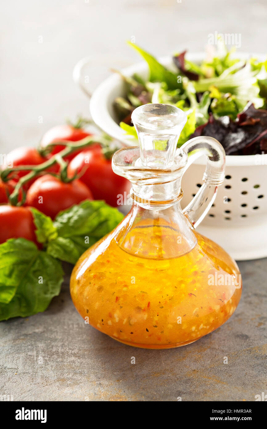 Italian vinaigrette dressing in a vintage bottle with fresh vegetables ...