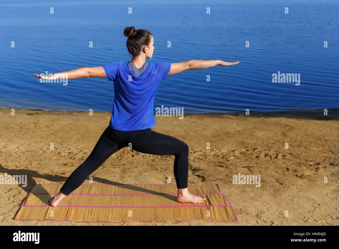 Woman practicing yoga outdoors Stock Photo
