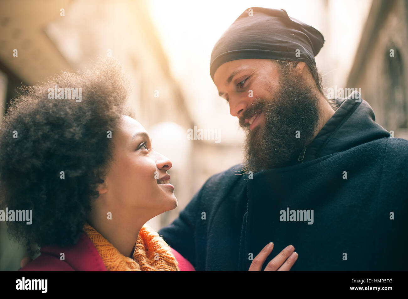 Portrait of romantic multiethnic couple in love hugging on the street ...