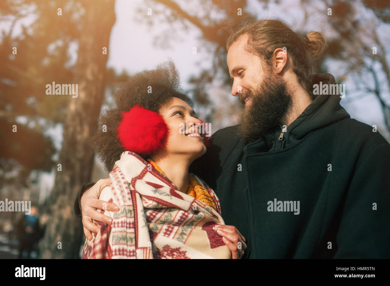 Portrait of romantic multiethnic couple in love hugging on the street ...