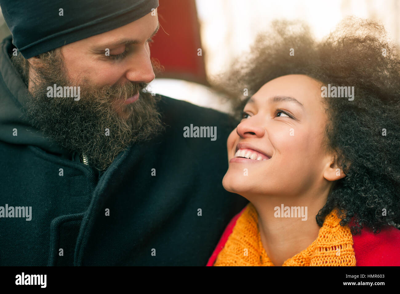 Portrait of romantic multiethnic couple in love hugging on the street ...
