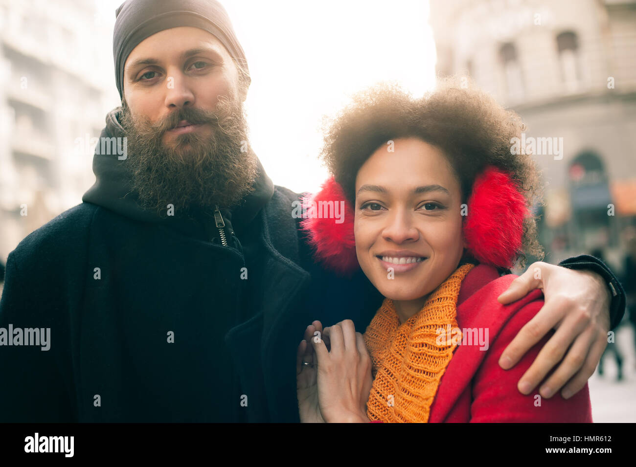 Portrait of romantic multiethnic couple in love hugging on the street ...