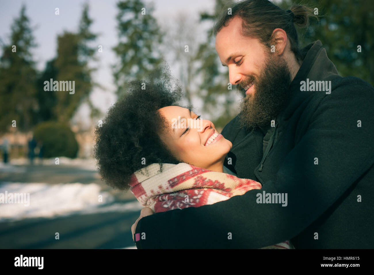 Portrait of romantic multiethnic couple in love hugging on the street ...