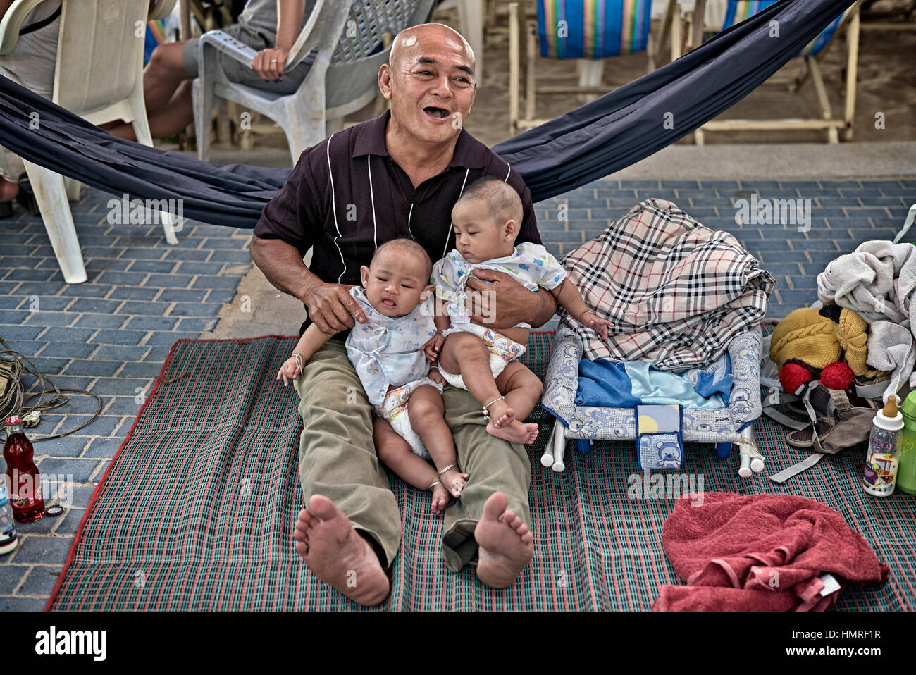 Thailand twins, Thai grandfather with his identical 4 month old twin grandchildren, Thailand twins, S.E. Asia Stock Photo
