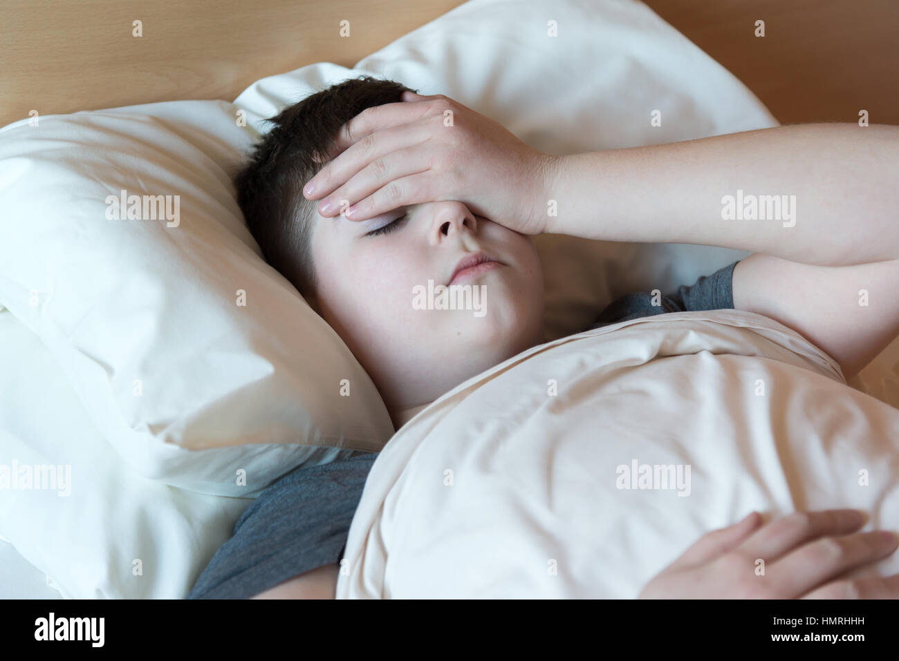 boy with headache lying in bed Stock Photo Alamy