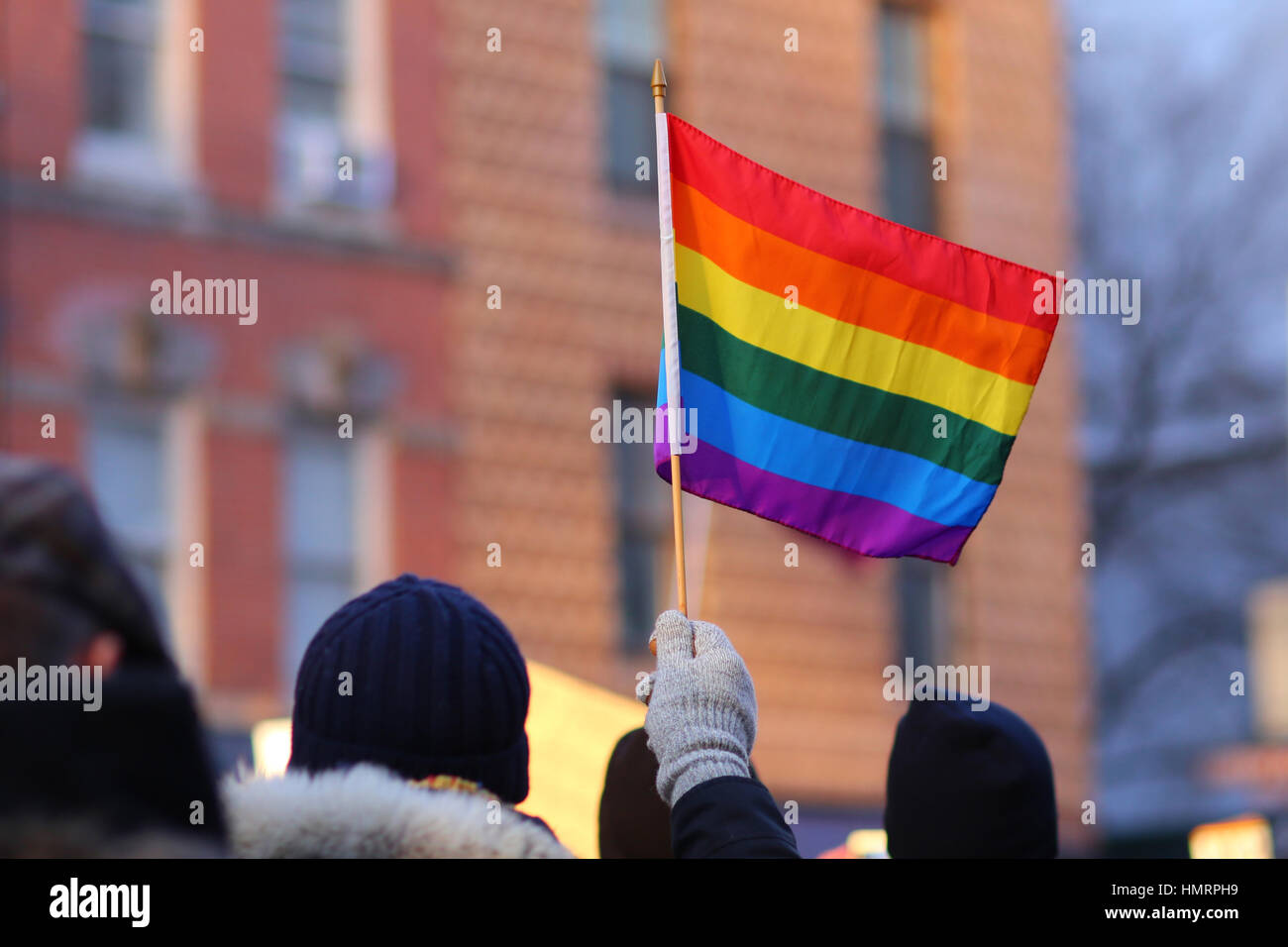 New York, USA. 4th February, 2017. A person waves a pride flag to show solidarity with those affected by recent policies made by Donald Trump. February 4, 2017 Stock Photo