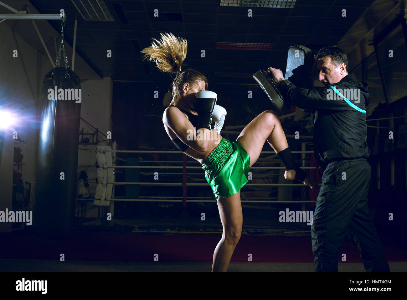 Girl doing knee kick exercise during kickboxing training with personal trainer Stock Photo Alamy