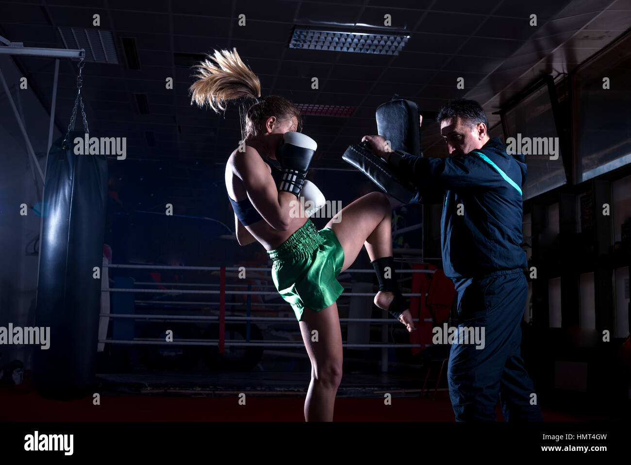Girl doing knee kick exercise during kickboxing training with personal trainer Stock Photo Alamy