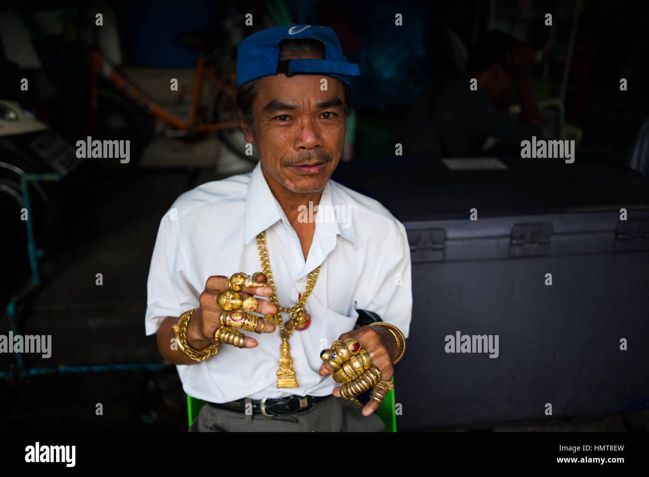 Man with golden rings in Bangkok, Thailand Stock Photo