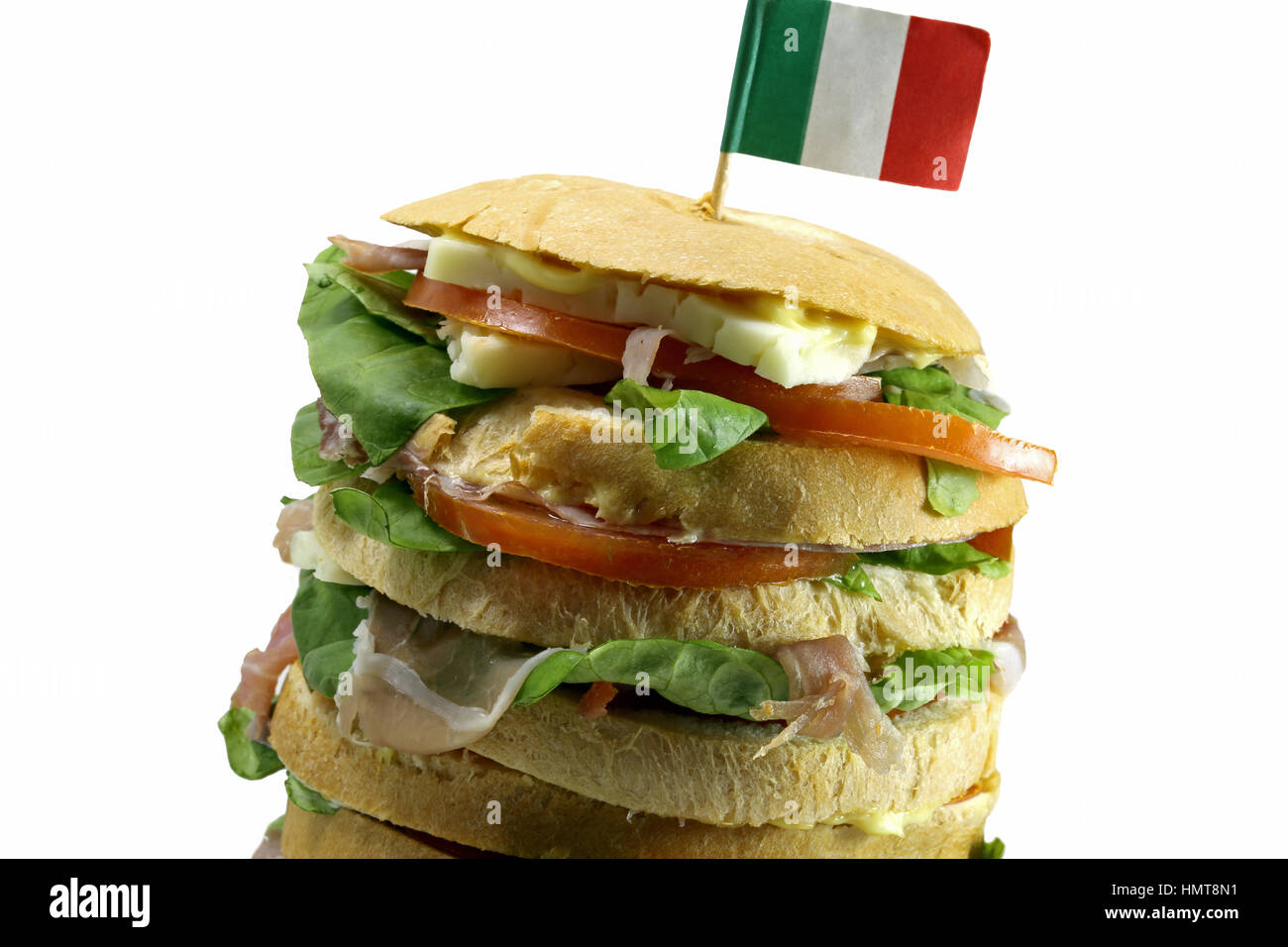 gourmet stuffed sandwich called Panettone Gastronomic with many layers of salami cheese and tomatoes typical Italian appetizer and the italian flag Stock Photo