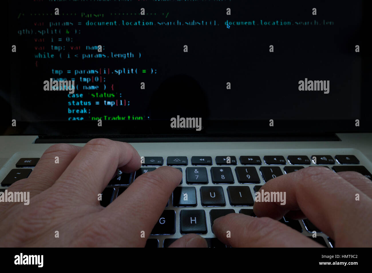 Man typing code on laptop computer Stock Photo