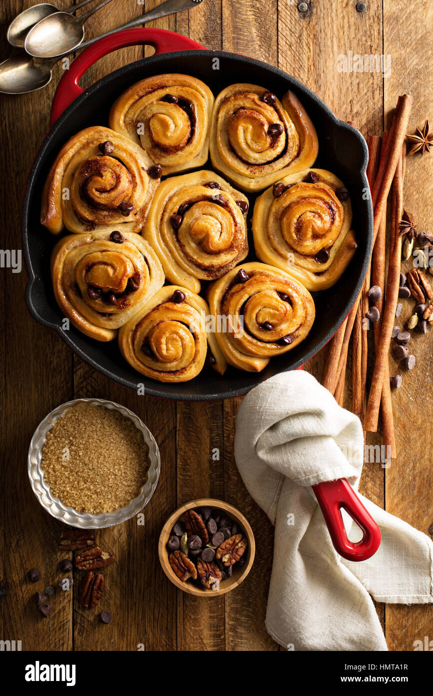 Cinnamon buns with chocolate chips baked in a cast iron pan overhead