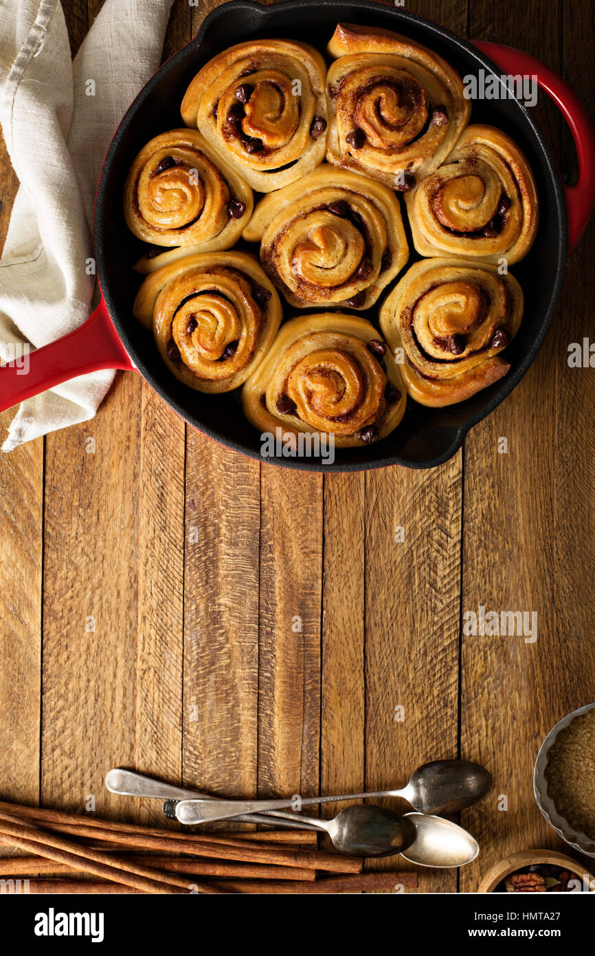 Cinnamon buns with chocolate chips baked in a cast iron pan overhead