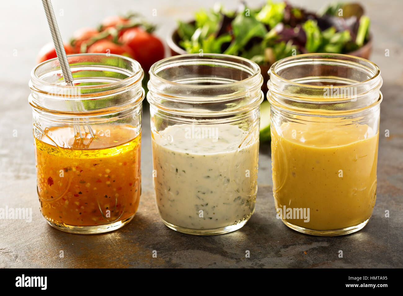 Variety of homemade sauces and salad dressings in mason jars including vinaigrette, ranch and