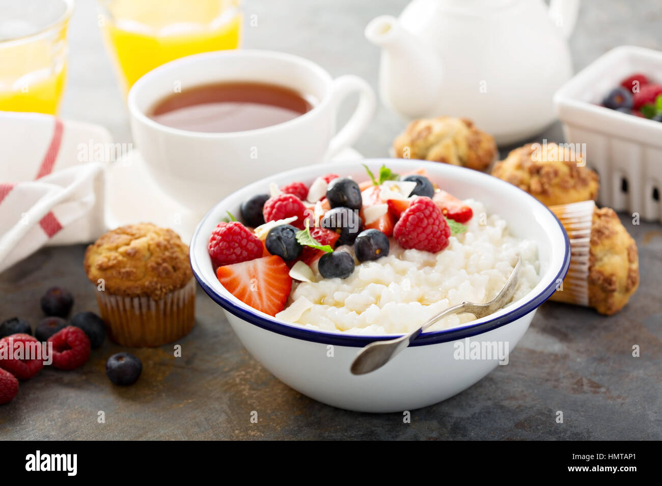 Rice pudding with fresh berries and coconut flakes for breakfast Stock