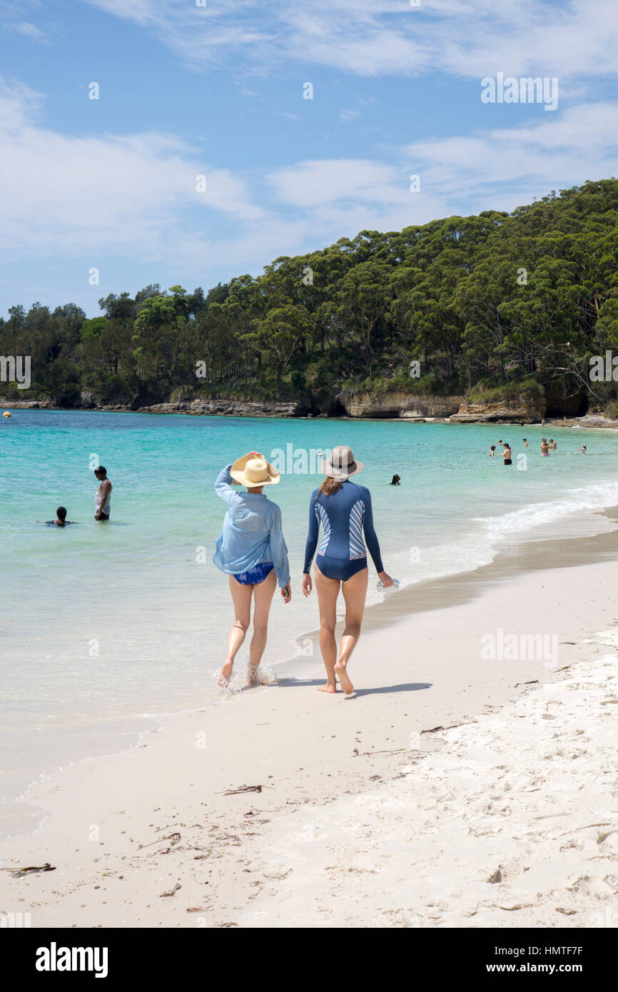 Two ladies walk along the shore at Murray's Beach in Booderee National ...