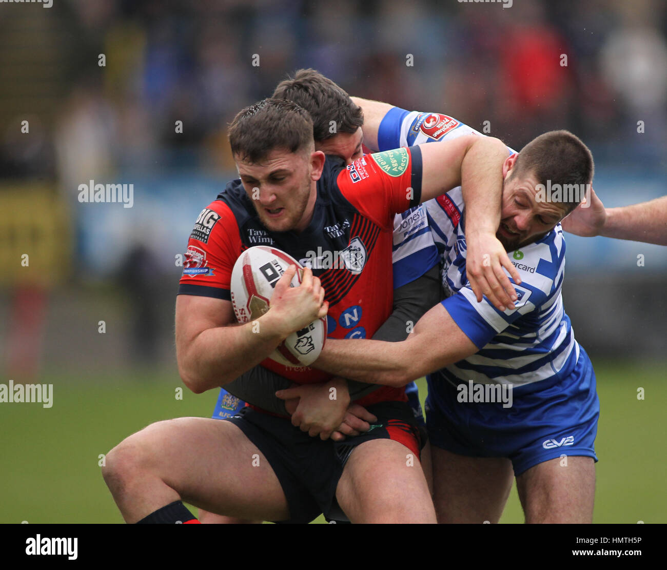 The Shay Stadium, UK. 05th Feb, 2017. The Shay Stadium, Halifax, West Yorkshire 5th February 2017. Halifax v Featherstone Rovers Jordan Baldwinson (C) of Featherstone Rovers tackled by Scott Murrell and Ben Heaton of Halifax RLFC during the Rugby League Championship 2017 Round 1 at the The Shay Stadium, Halifax. Picture by Credit: Stephen Gaunt/Touchlinepics.com/Alamy Live News Stock Photo