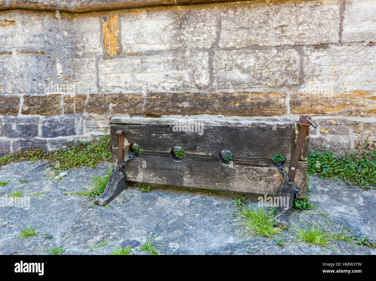 Traditional old wooden stocks in Cerne Abbas, a village in Dorset, south-west England, in summer Stock Photo
