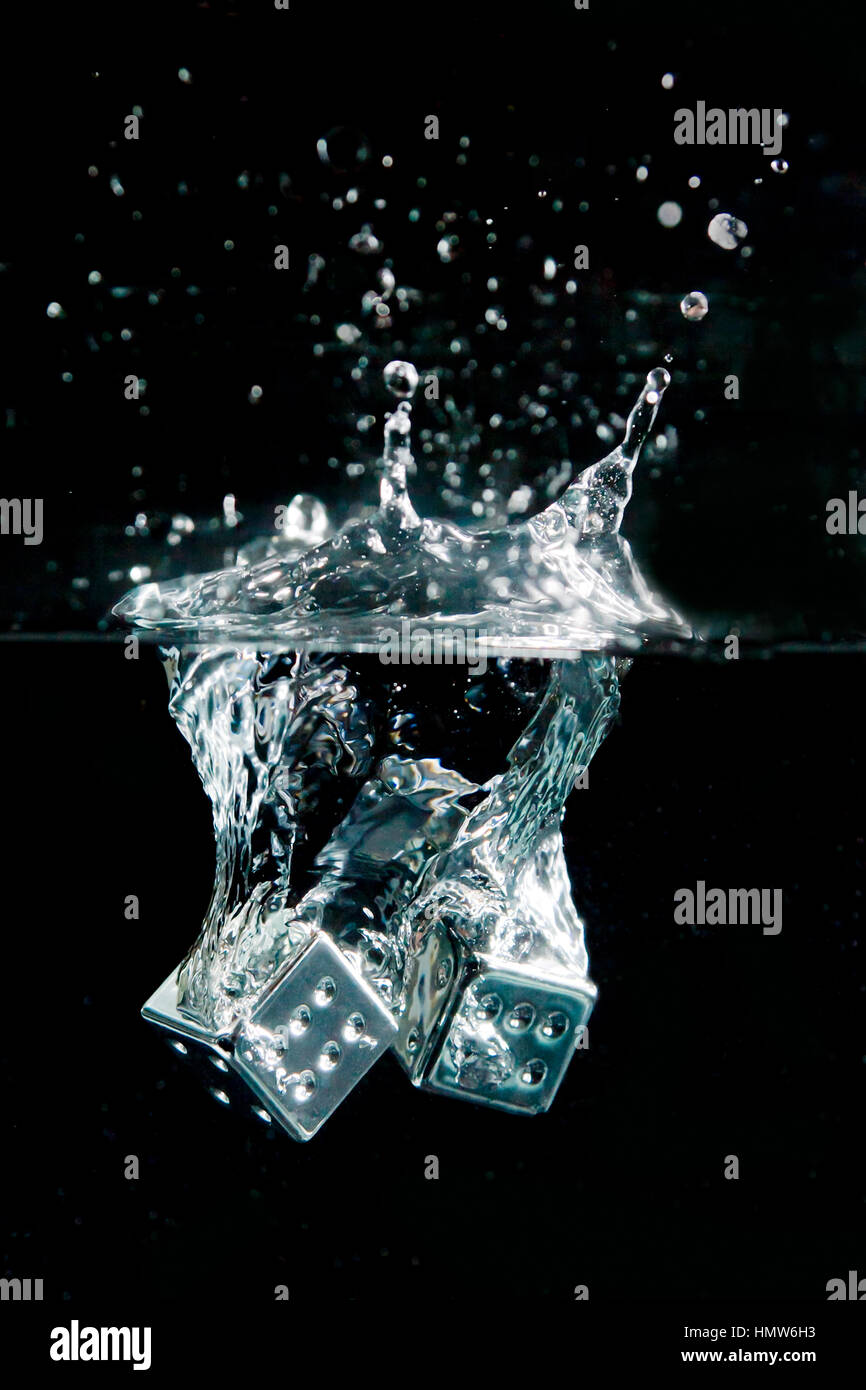 two silver shiny dice dropped into water showing double six Stock Photo