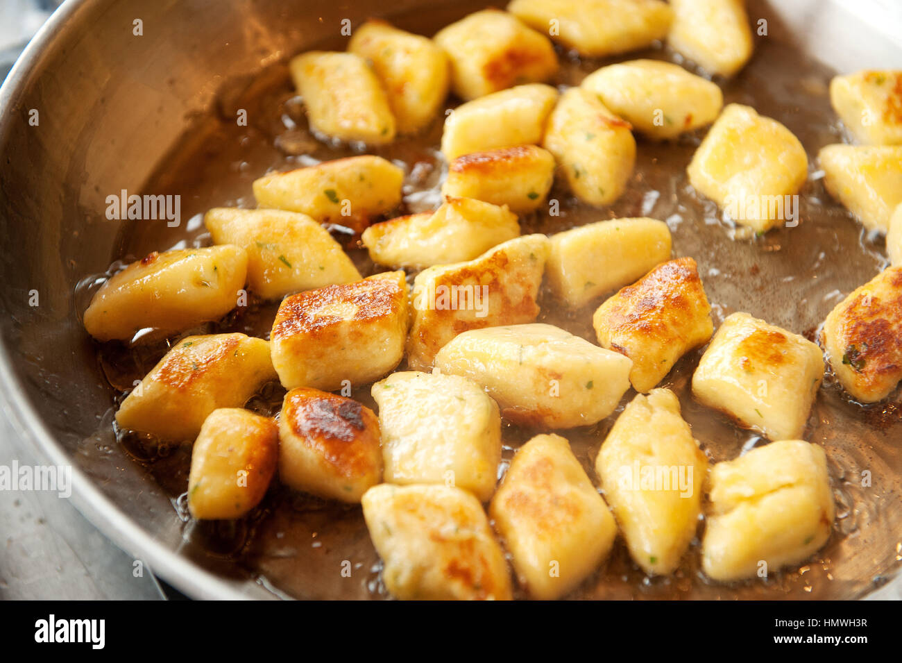 Gnocchi dumplings fry in duck fat in a skillet pan. Gnocchi are various