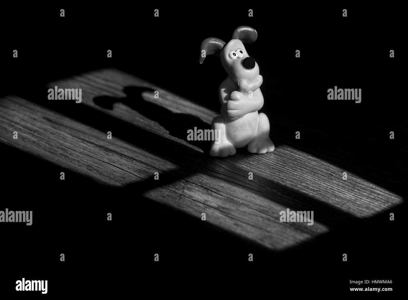 Gromit Deep in thought lit by moonlight.    I cut four rectangles into a piece of black card. I then shone a spot light torch through the card to give Stock Photo