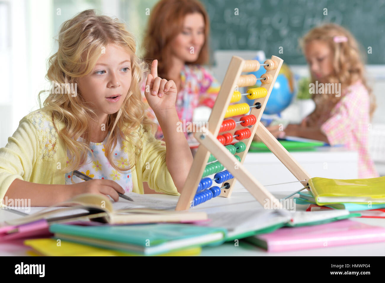 teacher with two girls at lesson Stock Photo - Alamy