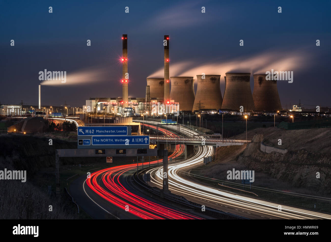 Ferrybridge Power Station, Knottingley Yorks UK. Light trails from the A1(M) Motorway pass by the backdrop of steaming cooling towers. Stock Photo