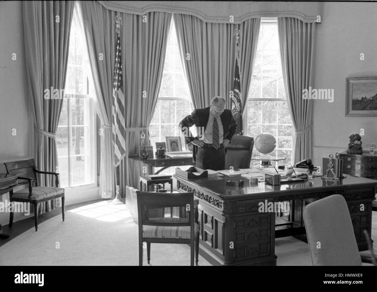 https://c8.alamy.com/comp/HMWXE9/us-president-gerald-ford-works-standing-behind-his-desk-in-the-oval-HMWXE9.jpg