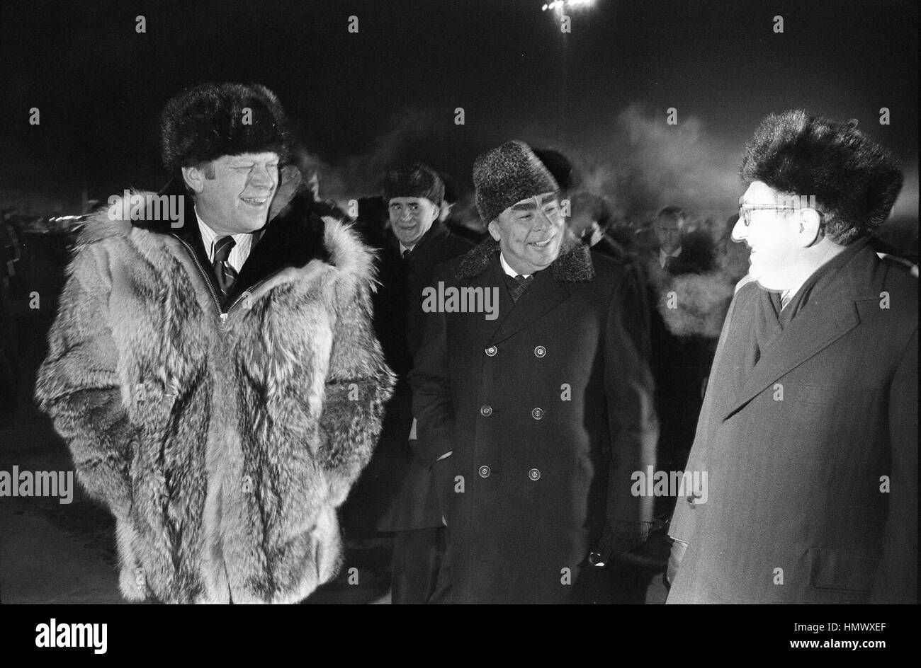 U.S President Gerald Ford wearing a Russian fur hat and wolfskin coat chats with Soviet General Secretary Leonid Brezhnev, center and Secretary of State Henry Kissinger at Vozdvizhenka Airbase before departure November 24, 1974 in Vladivostok, Russia, USSR. Ford is departing at the conclusion of a two-day summit on Arms Control. Stock Photo