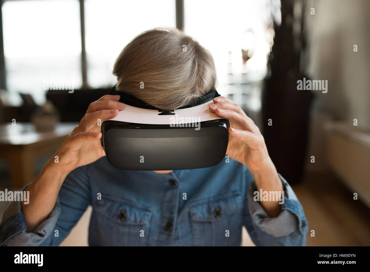 Senior woman wearing virtual reality goggles at home Stock Photo Alamy