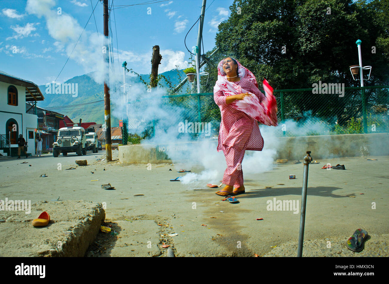 Kashmir Uprising 2016: A woman throws a tear smoke shell back at forces during a protest rally in Indian-administered Kashmir on  19 August 2016. Stock Photo