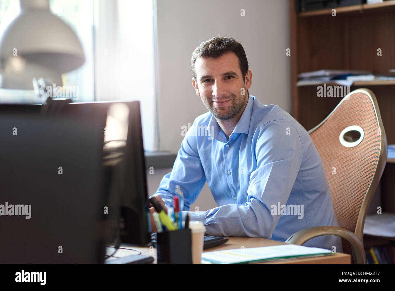 Smiling businessman at work in an office Stock Photo