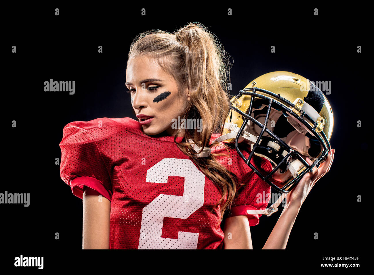 Female football player posing with helmet Stock Photo Alamy