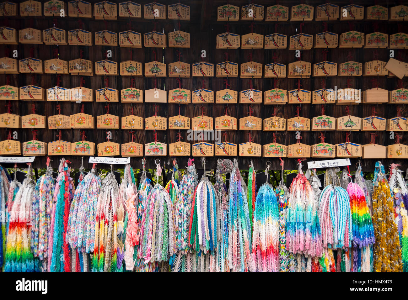 Small wooden plaques with prayers and wishes & colourful paper cranes at Fushimi Inari Taisha (Shinto shrine), Kyoto, Japan Stock Photo