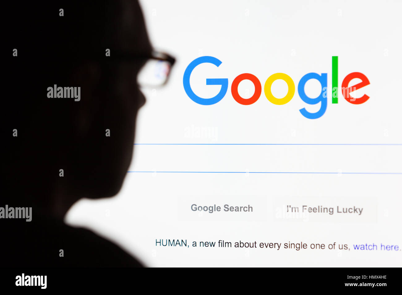 BATH, UK - SEPTEMBER 12, 2015: Close-up of the Google.com search homepage displayed on a LCD computer screen with the silhouette of a man's head out o Stock Photo