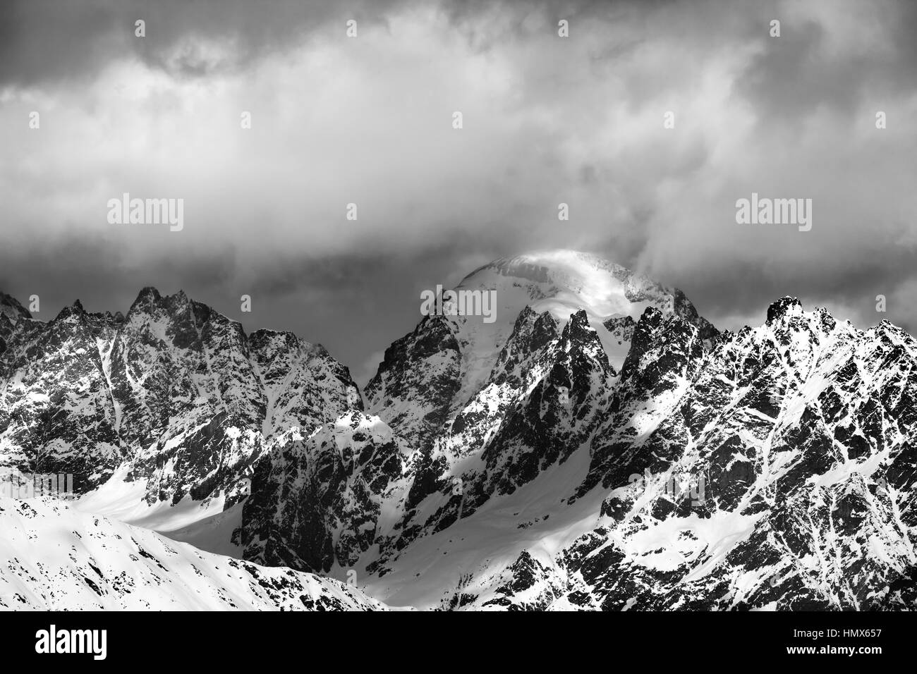 Black and white snow mountains in clouds at sunny winter day. Caucasus Mountains. Svaneti region of Georgia. Stock Photo