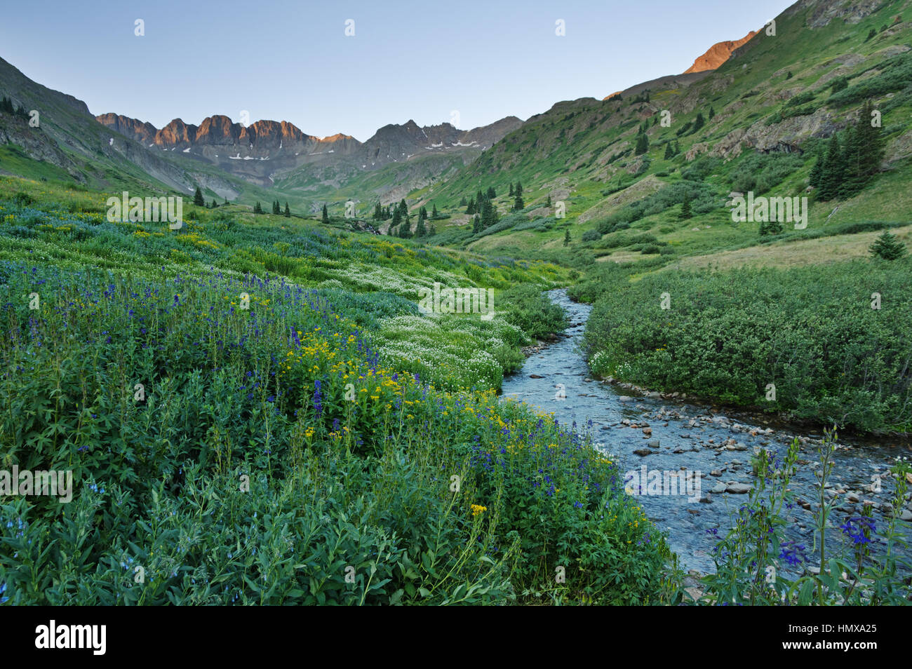 sunrise lighting up the mountains above American Basin in the San Juan Range of Colorado Stock Photo