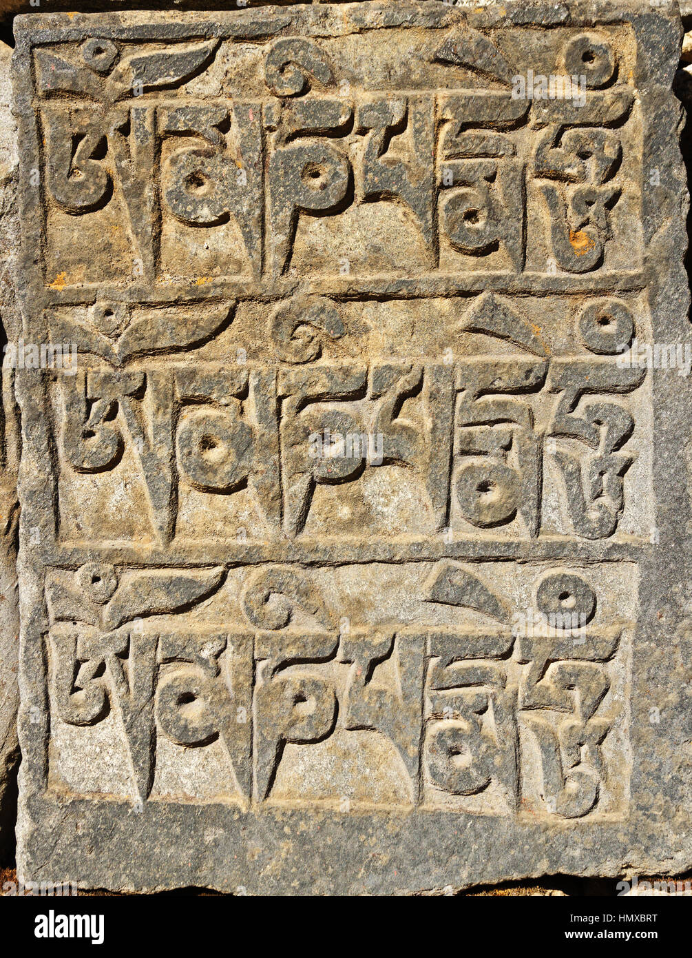 carved mani stone with the words om mani padme hum Stock Photo