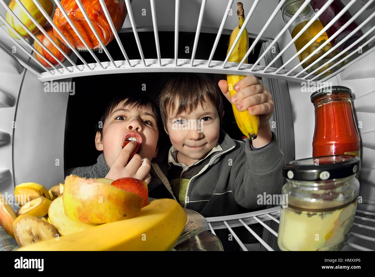 children open the door and take the food out of the fridge Stock Photo