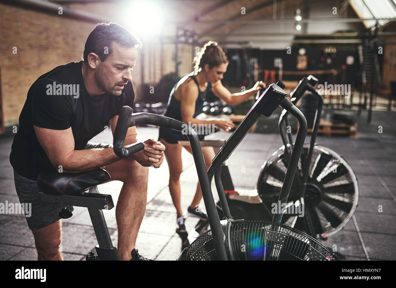 Two young athletic people in sportswear training in gym on bodybuilders. Stock Photo