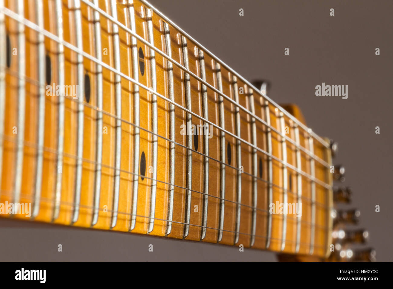 Close up of a Fender Telecaster electric guitar maple neck , frets,steel strings and inlay markers Stock Photo