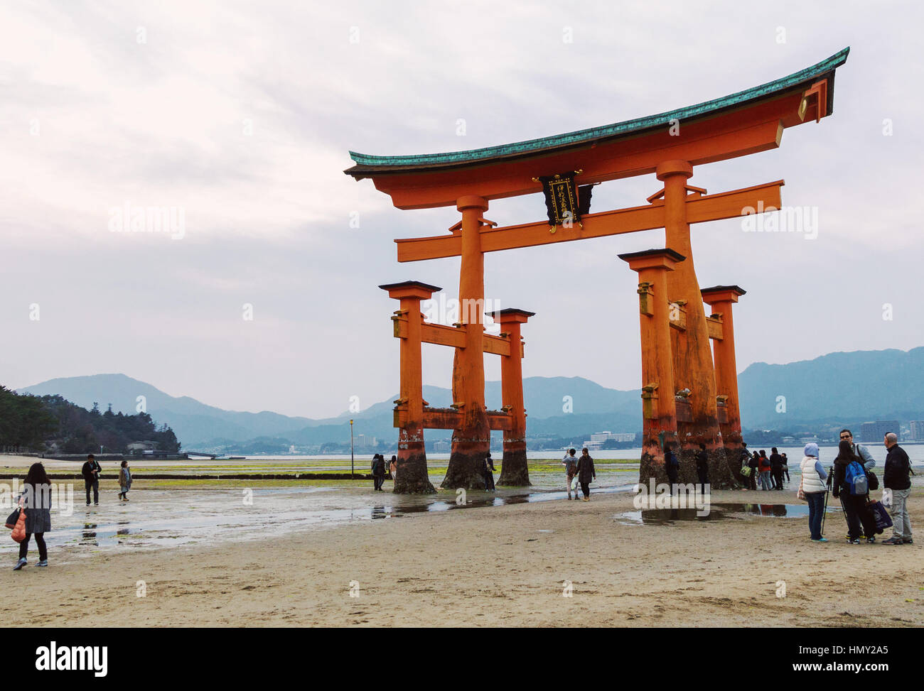 People enjoy the huge floating torii gate of the Itsukushima Shrine at low tide in the evening in Miyajima island, J Stock Photo