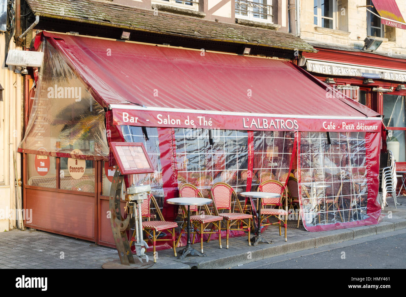 Street cafe with outdoor tables and chairs under cover in Honfleur, Normandy, France Stock Photo