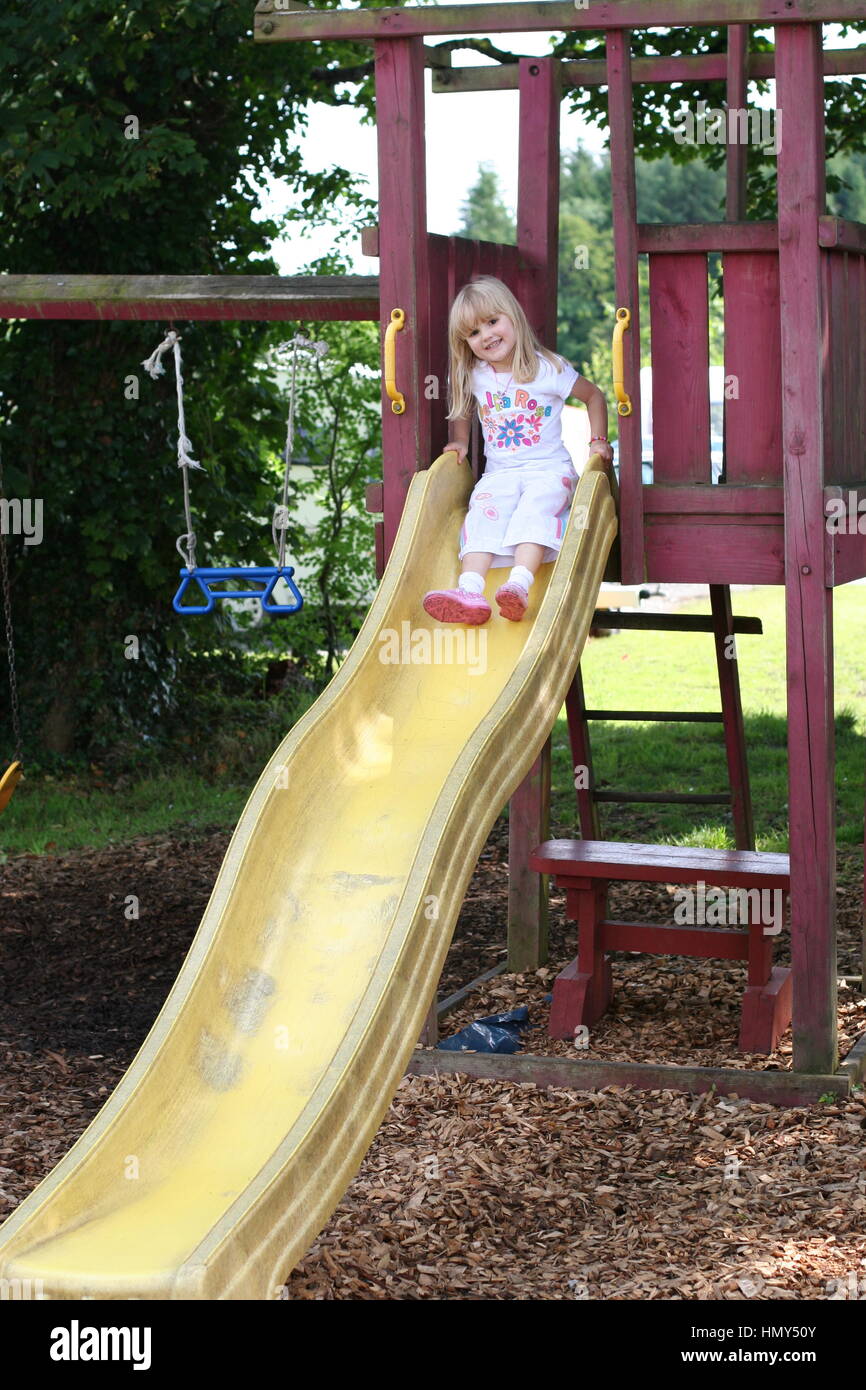 little girl on the slide in a wooden playground Stock Photo - Alamy