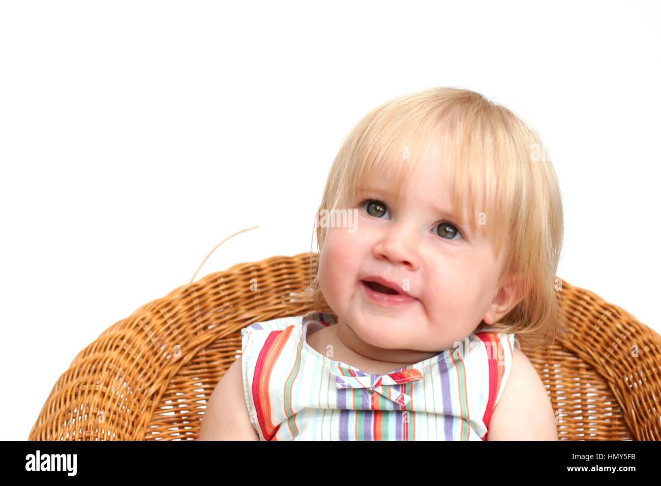 Child, Little toddler sitting in a wicker chair Stock Photo - Alamy
