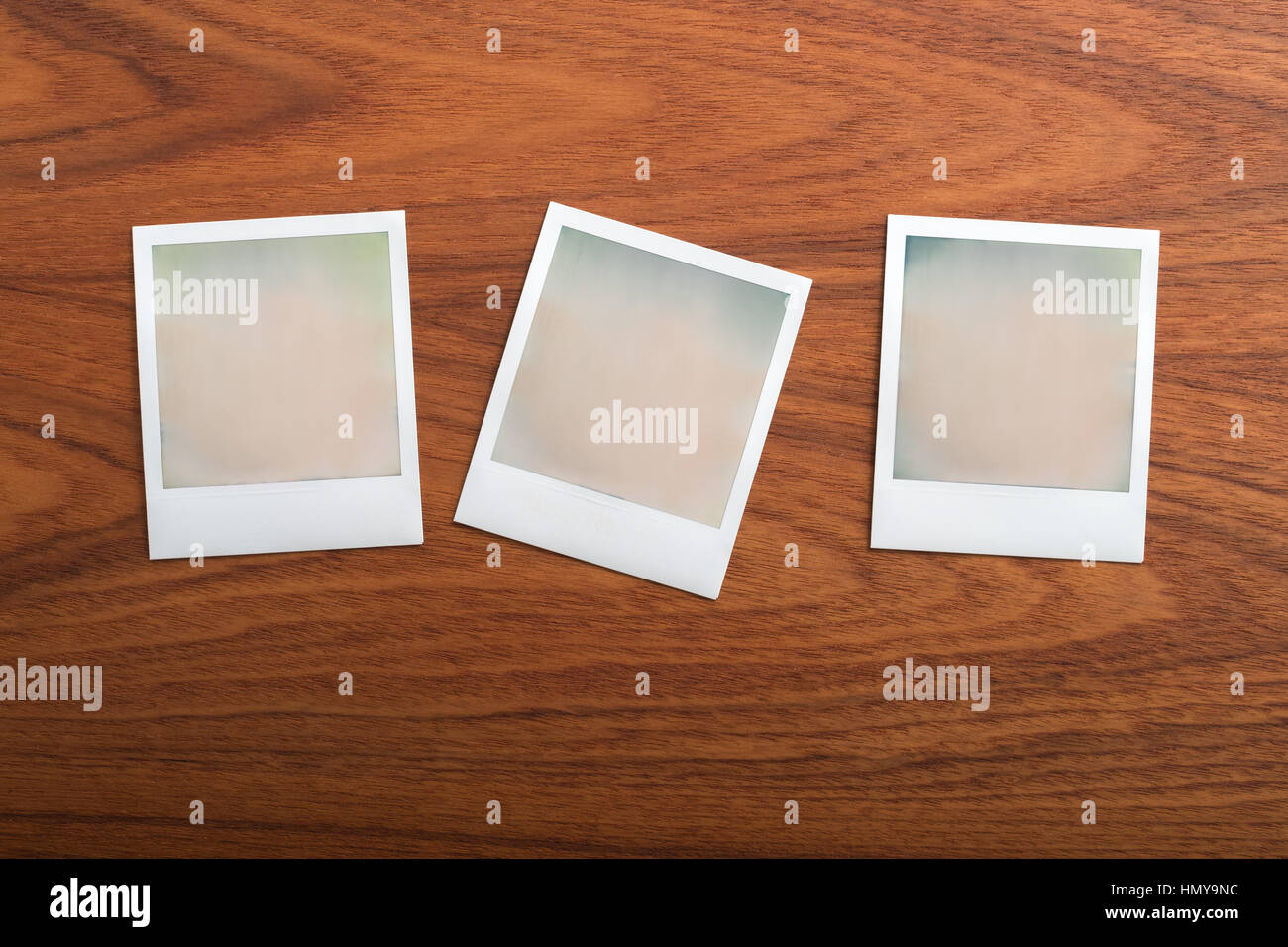 Blank instant print photographs on wooden table. Three Objects. Stock Photo
